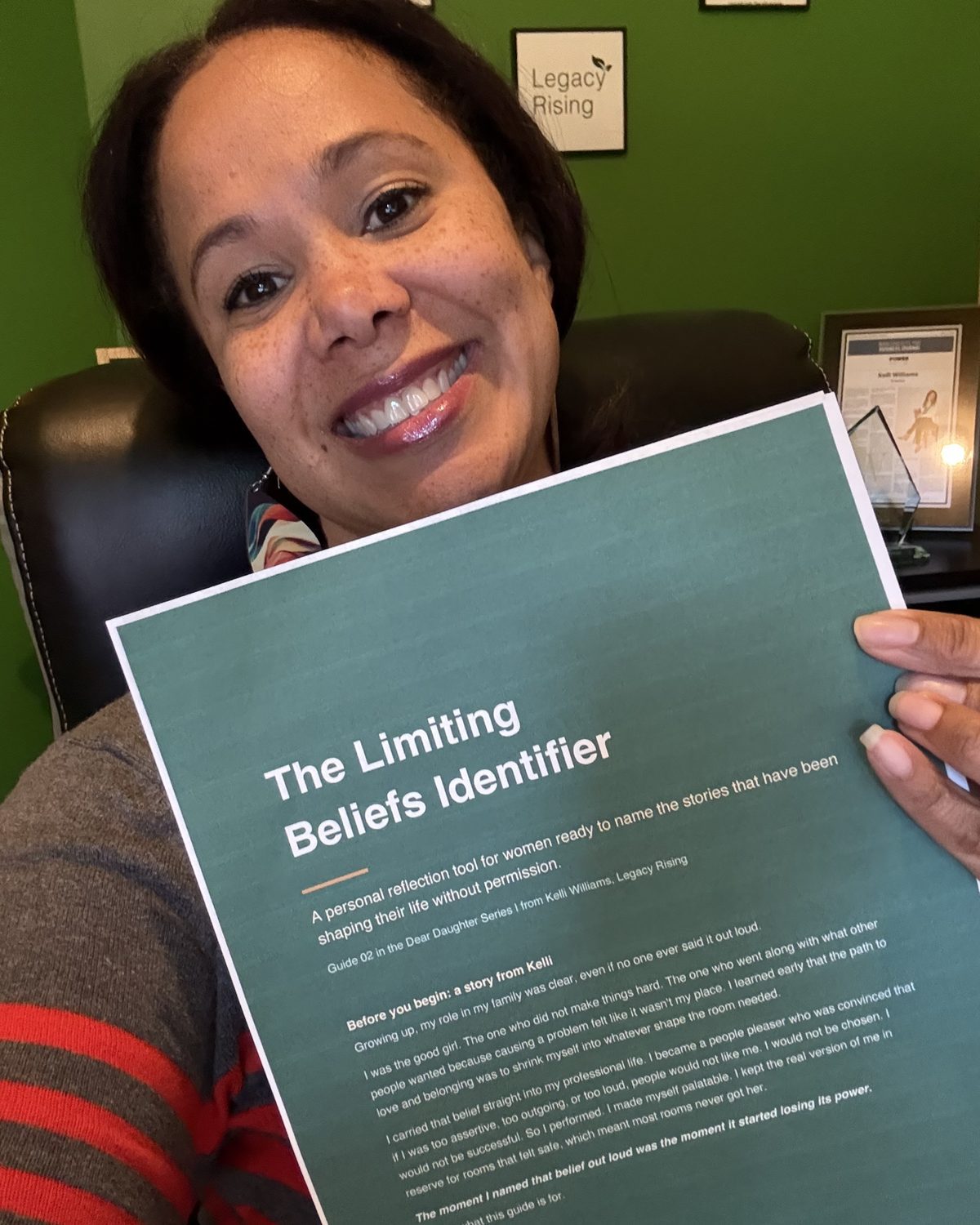 Kelli Williams smiling while holding a printed copy of The Limiting Beliefs Identifier, Guide 02 in the Dear Daughter Reflection Guide series